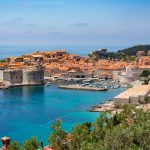 Scenic view of Dubrovnik's historic old town with iconic city walls and Adriatic coastline.