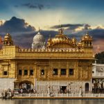 Stunning view of the Golden Temple in Amritsar, India, with a vibrant sunset sky.