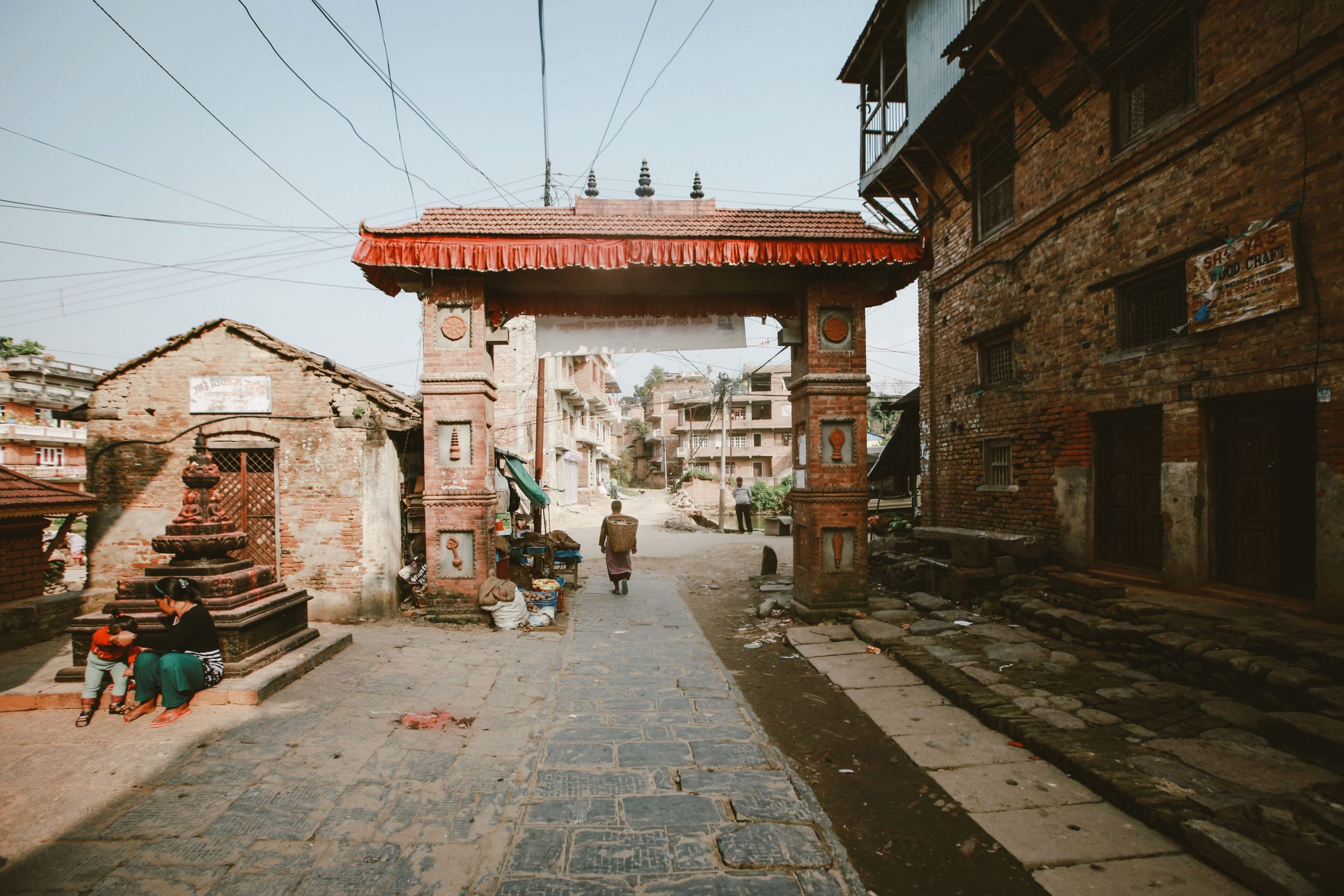 A historic Nepalese archway in a vibrant urban street, showcasing traditional architecture.