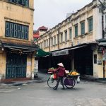 Street vendor with a bicycle in the urban market of Hanoi, Vietnam.
